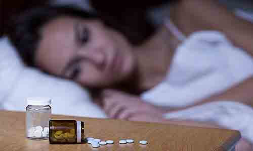 女人睡不著看著在桌上的安眠藥