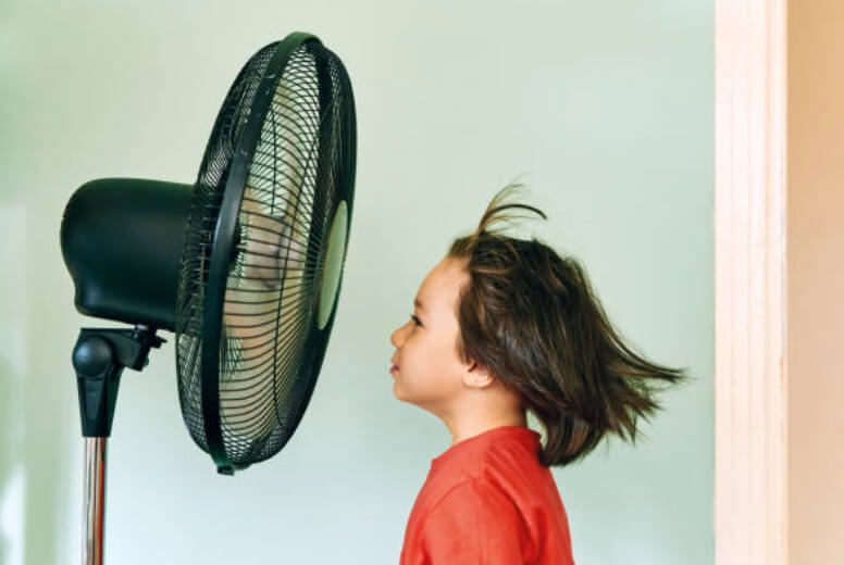 紅衣小女孩對著電風扇