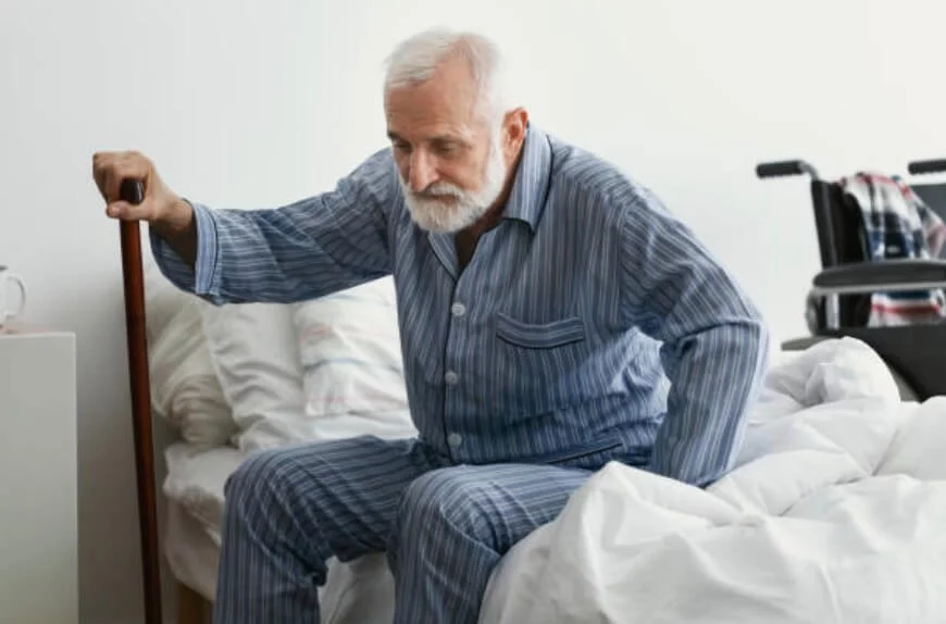 老年人撐著枴杖坐在床邊想站起來
