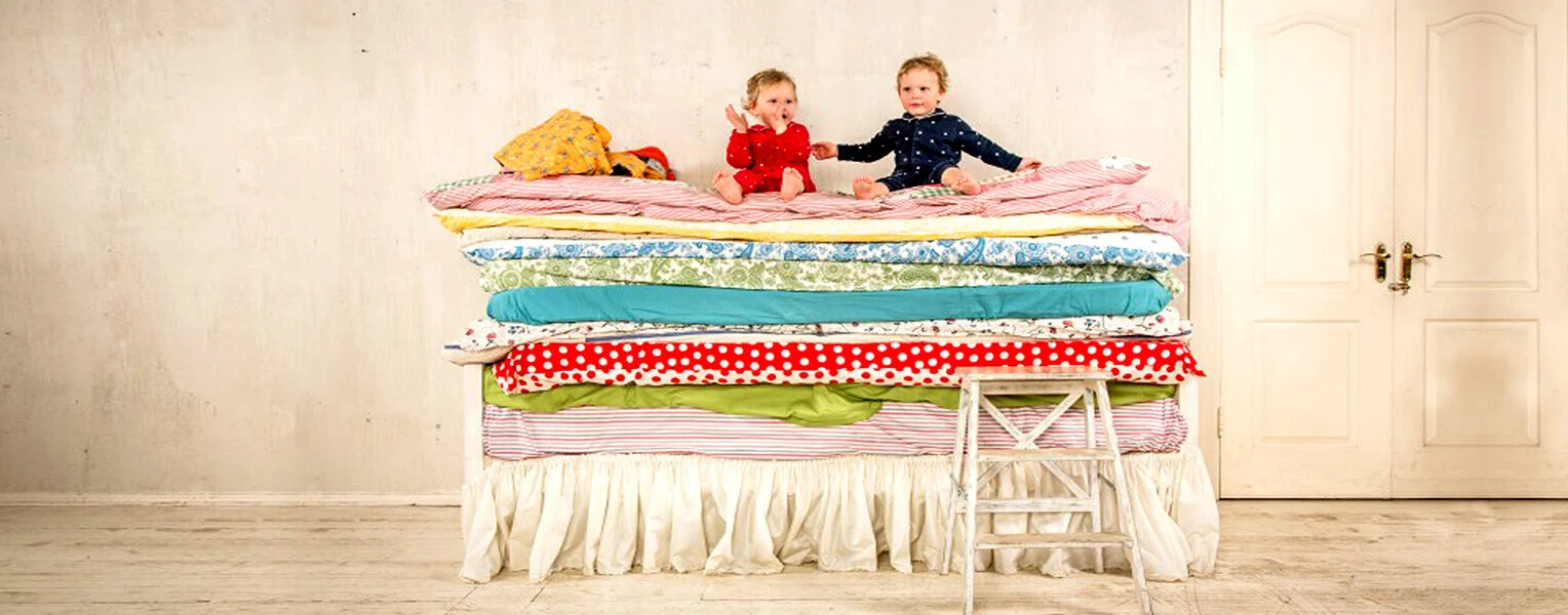 2個小孩坐在好幾層床墊上