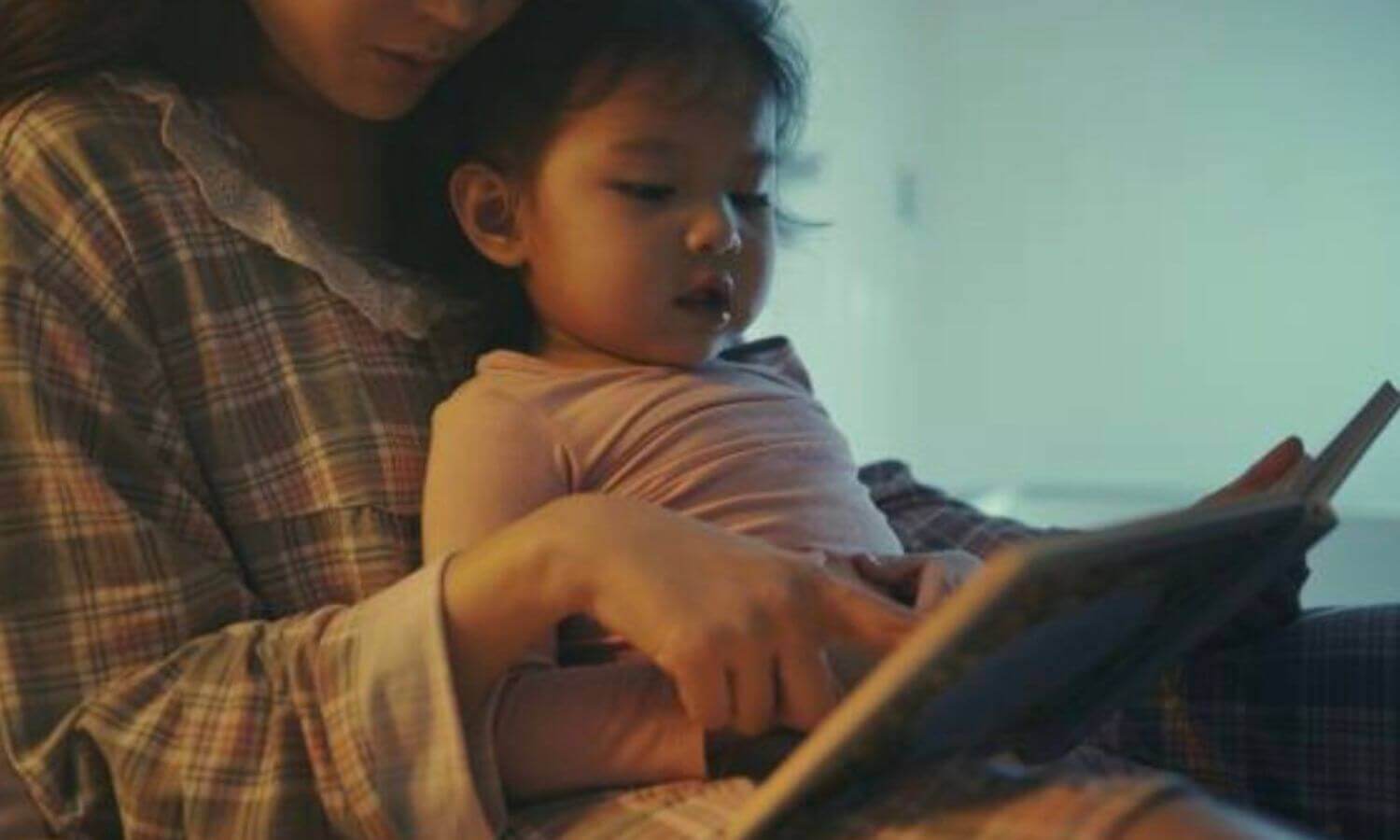 在床上讀繪本或故事給孩子聽，讓幼兒放鬆情緒轉換為睡覺的心情
