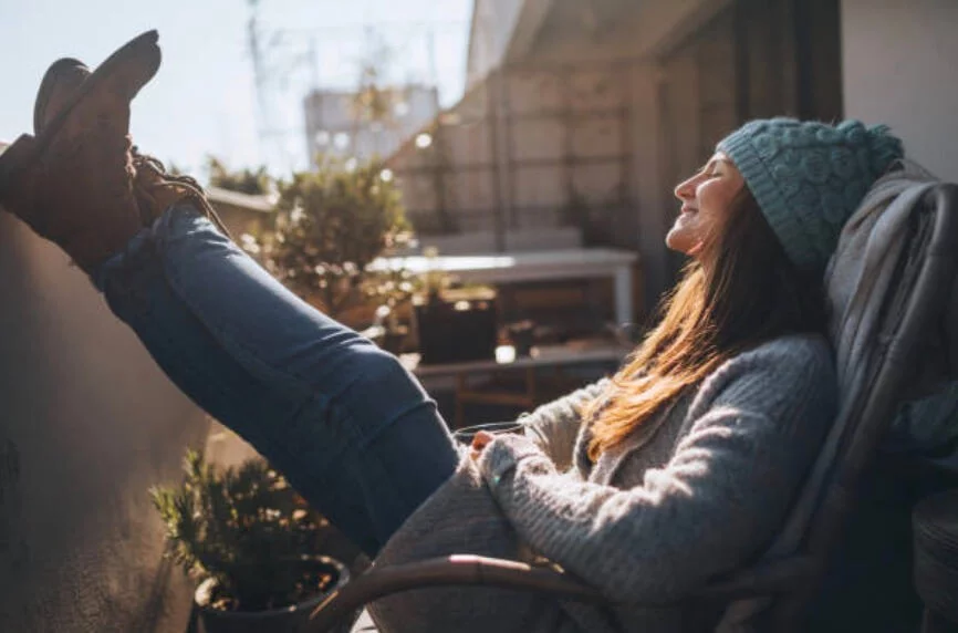 女人在陽台開心的享受太陽的溫暖