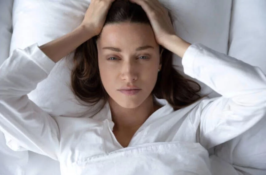 女人躺在床上抱頭煩惱厭世