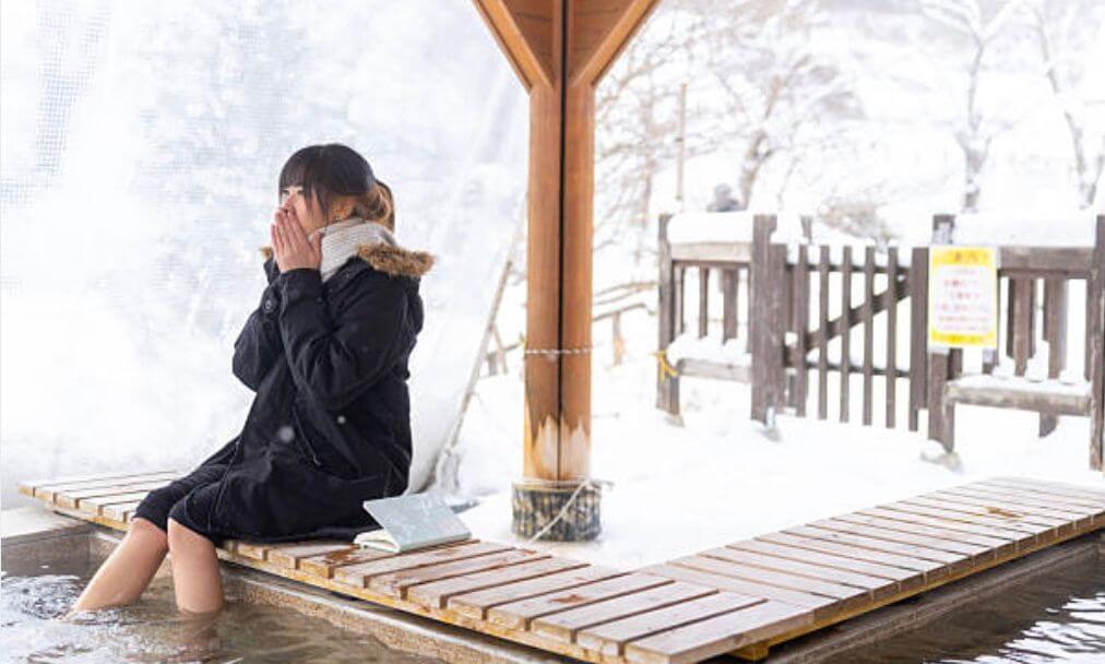 女性在冬天的溫泉區泡腳