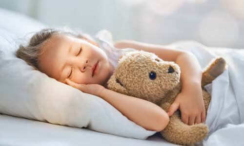 小女孩側睡抱著熊布偶